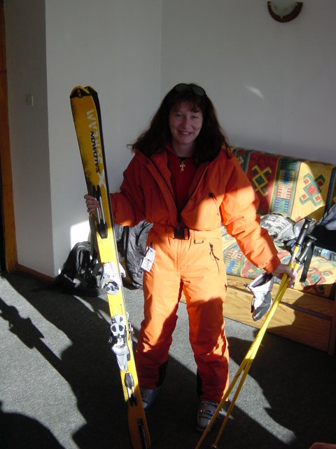Sophie en combinaison tenant skis et batons