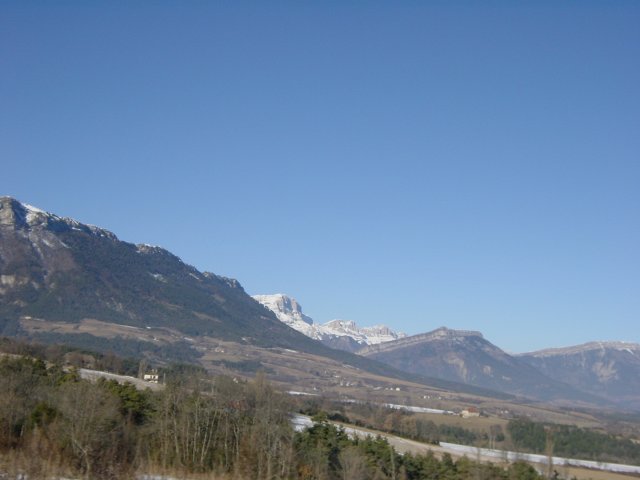 Plaine, brume, montagnes enneigees