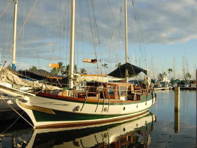 Steel-gray-blue water, green-white-brown boat, cloudy gray-blue-white sky