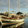 Steel-gray-blue water, green-white-brown boat, cloudy gray-blue-white sky