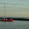 Sailing ship on the lake with the ocean just behind