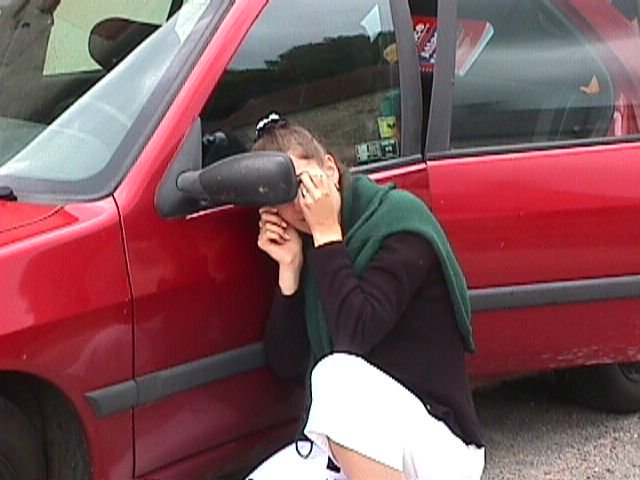 Coralie se fait une beaute rapidement devant le retroviseur de la 306