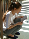 Coco accroupie sur le balcon, bouquin a la main