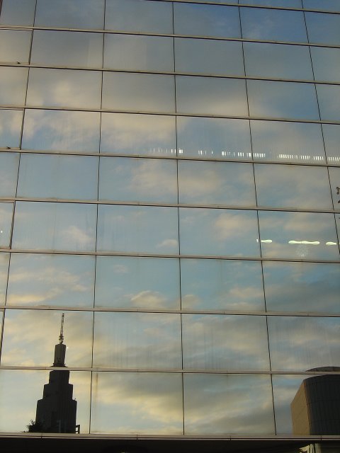 Reflection of blue sky, clouds and buildings in a glass building