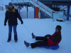 Alex tient la luge ou Steph est assis