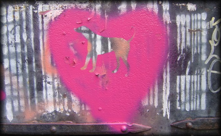 Graffiti on a door: white barcodes and stencil of a dog in a pink heart