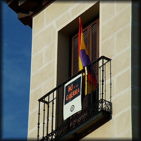 Flag and poster "NO a la GUERRA" on a balcony