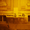 Graffiti on the wall reading "Autogestiona tu vida" and showing a carrot and a sun.