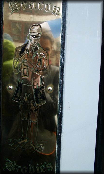 Reflection of myself behind the Deacon. This is the plaque outside Deacon Brodie's on the Royal Mile.