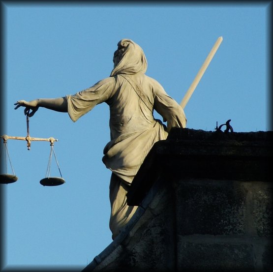 The scales of Justice. Justitia has frequently been depicted as a bare-breasted woman carrying a sword and scales, and sometimes wearing a blindfold.