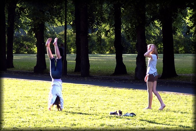 Two girls having fun (it seemed) doing gymnastics on the grass near the entrance of the Vigeland Sculpture Park.