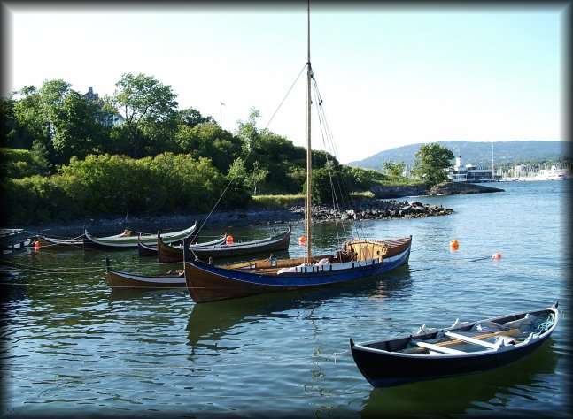 Rowing boats and sailing boat moored in the Oslo Fjord.