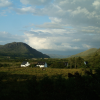 Clouds and blue sky, mountains, fields, houses.