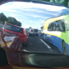 The reflection of cars and the bus we're on, in the chrome rearview mirror of the car next to our bus.