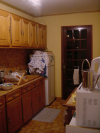 La cuisine: placards, evier, frigo, fenetre donnant sur le jardin, micro-onde