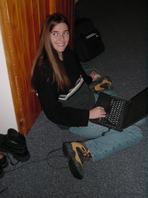 Coralie pliee dans le couloir avec son laptop
