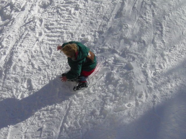 Petit garcon glissant de cote dans la neige
