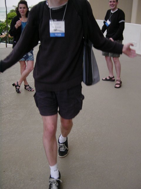 Max performing a model walk, Christelle and Hugo watching and laughing in the back