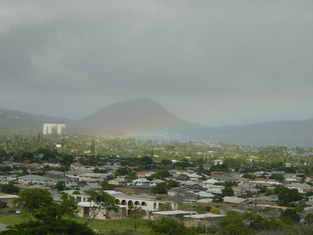 Rainbow over a patch of sunbathed land