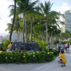 Japanese couple dressed in yellow and taking pictures of a fountain by the ocean