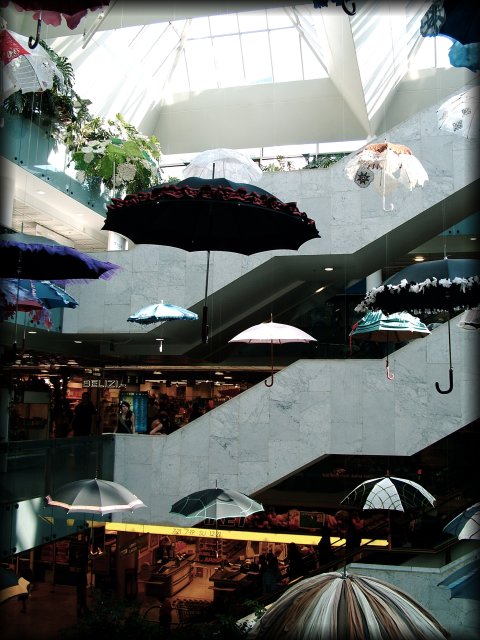 Umbrellas dangling from the ceiling in a mall.