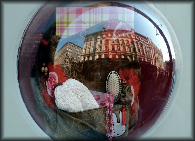 Buildings reflected in the window of a store.